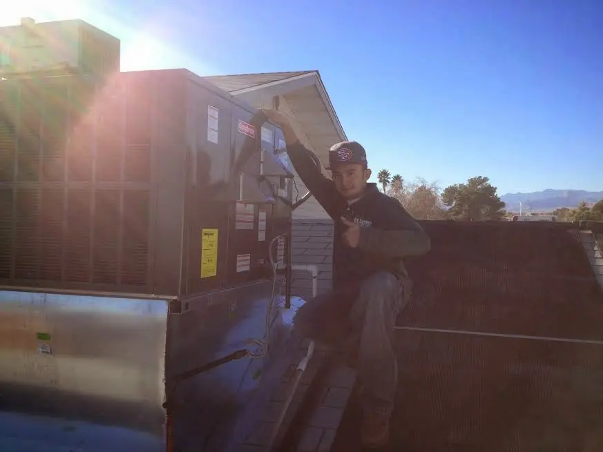 HVAC technician performing Heat Pump Repair on a rooftop unit in London